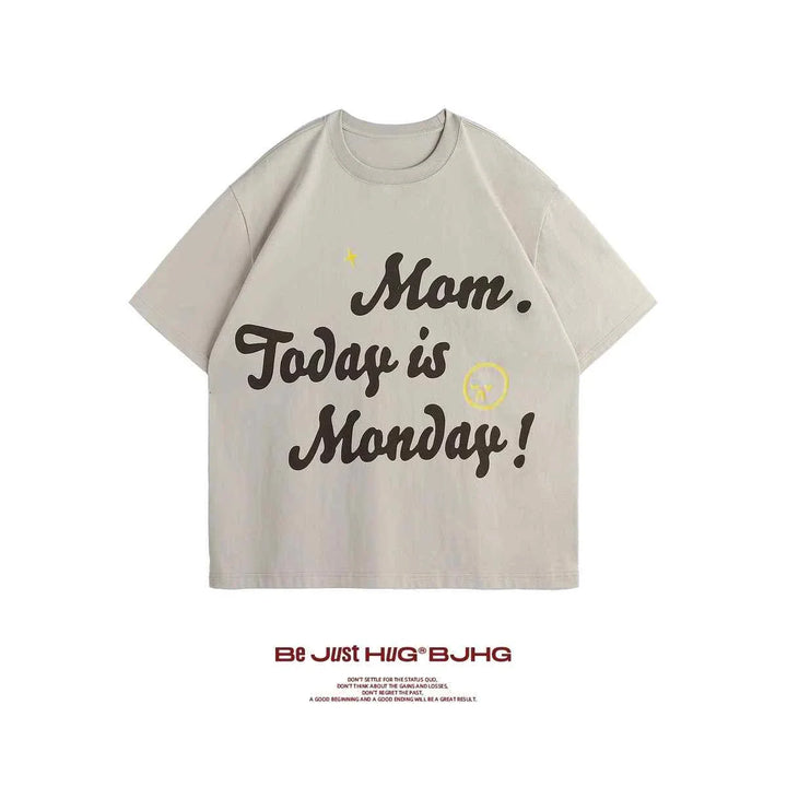 Casual beige T-shirt with "Mom Today is Monday!" printed in bold script and a small smiley face design