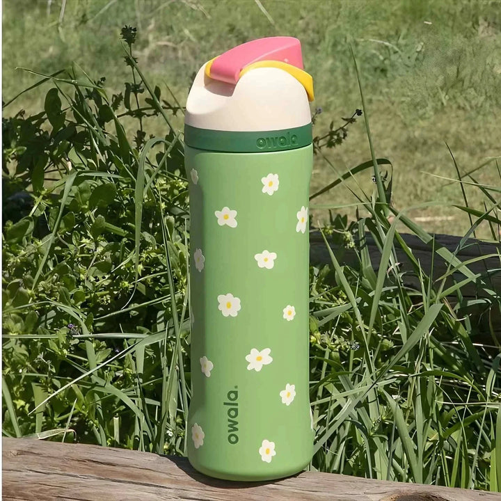 Green Owala FreeSip water bottle with white flower patterns and dual drinking spout, BPA-free and insulated for 24-hour cold drinks