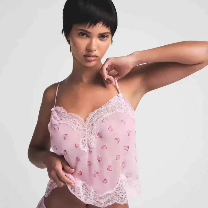 SKIMS lace heart print pajama set in soft pink sheer fabric with romantic lace trim on model