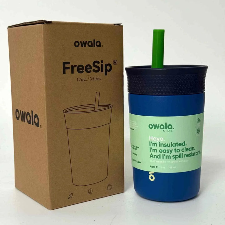 blue Owala FreeSip insulated kid's water bottle with green straw and spill-resistant design next to its cardboard packaging box