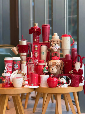 كوب Tumbler من Starbucks ذهبي مع حامل أحمر فاخر.