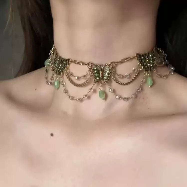 قلادة Choker بتصميم فراشات ذهبية وأحجار باللون الأخضر.
