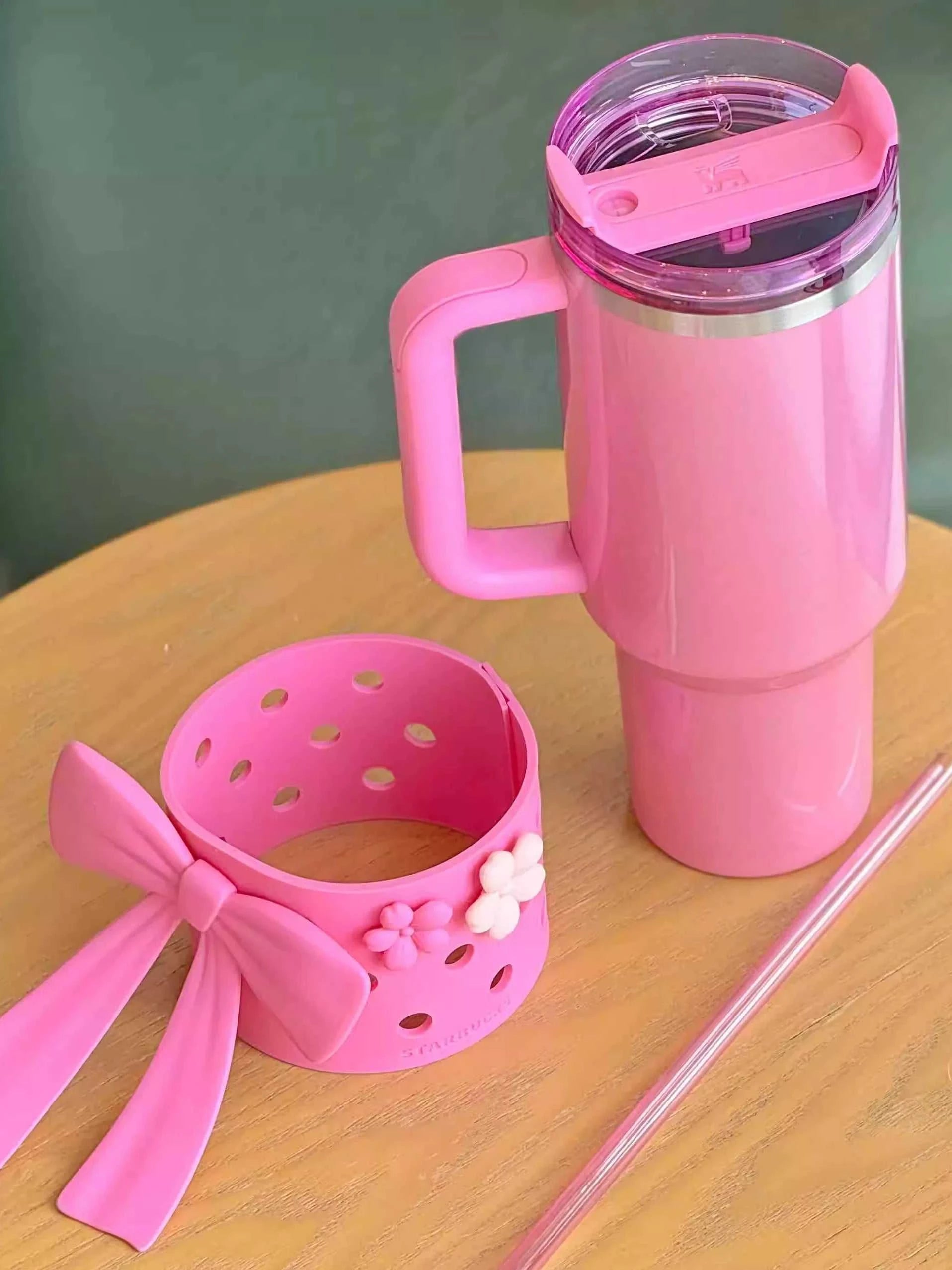 Tumbler Stanley Starbucks وردي مع إكسسوار فيونكة.