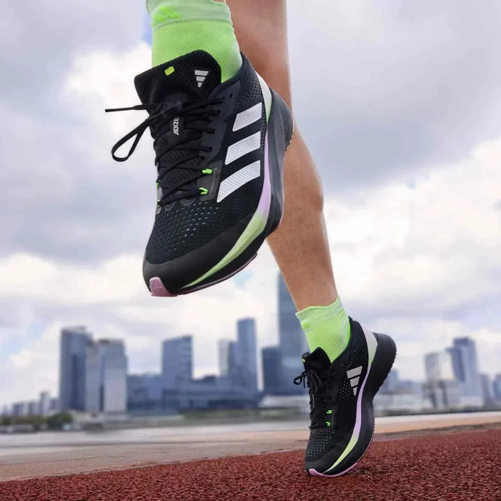 Adidas أديداس حذاء الجري السريع ADIZERO SL أسود مع خطوط بيضاء وسول ملون على مضمار جري حديث
