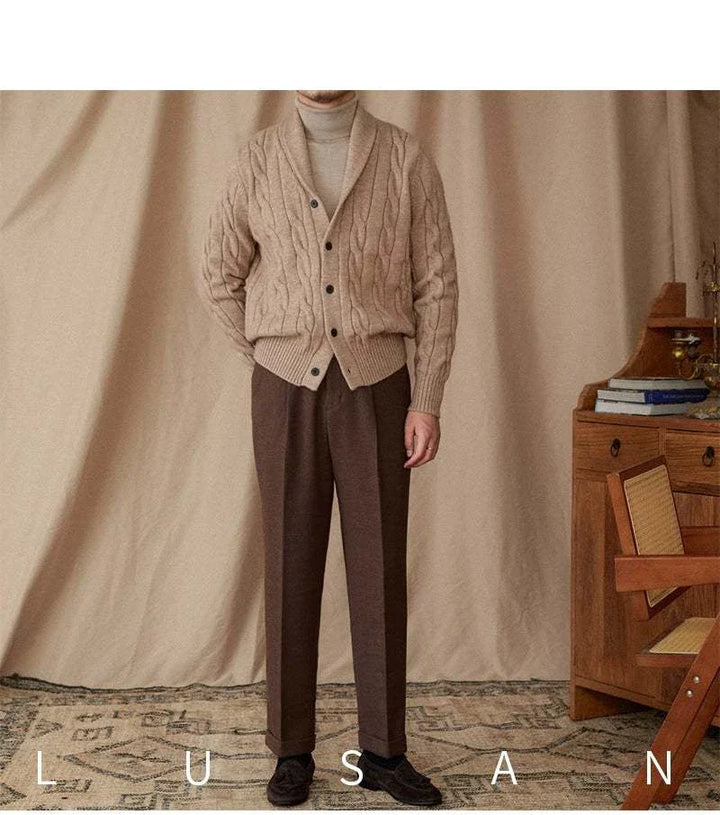 Man wearing beige cable knit Mr. Lusan cardigan with shawl collar and buttons paired with brown trousers in a cozy indoor setting