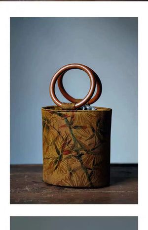 حقيبة يد Bucket Bag بتصميم خشبي دائري ولون خردلي مميز.