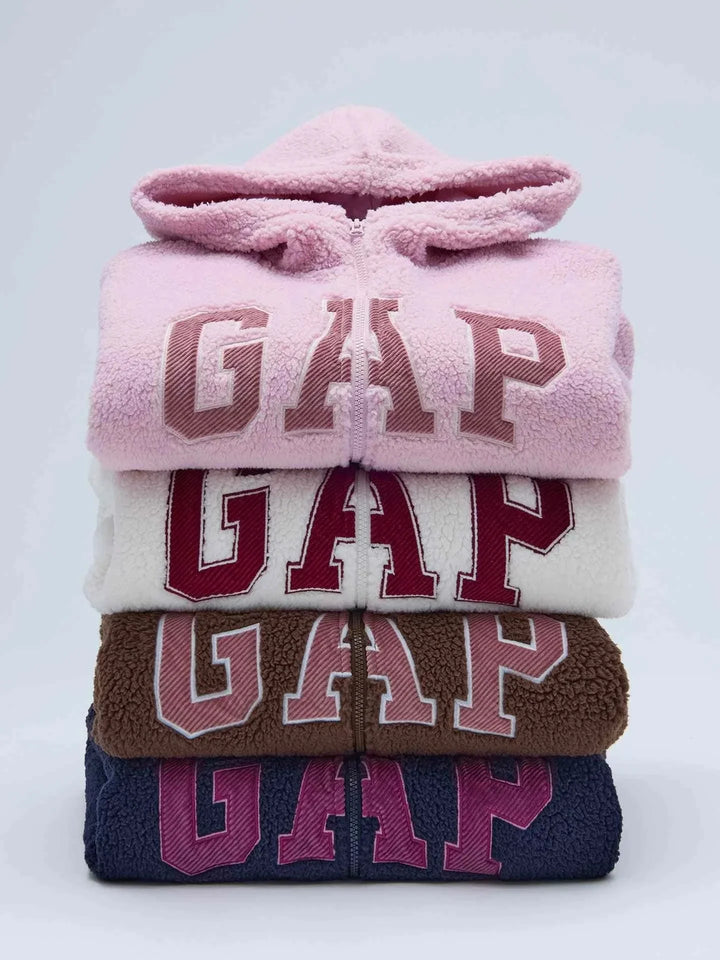 Stack of folded Gap هودي sherpa hoodies in pink, white, brown, and navy with large logo, soft winter fleece material