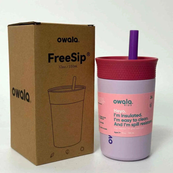 Owala FreeSip insulated kids cup with spill-resistant lid and integrated straw in purple and pink colors next to its brown cardboard packaging box, 12oz capacity.
