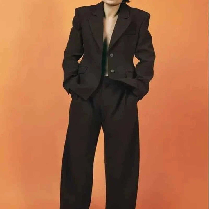 Women's European and American style black blazer and casual trousers set against orange background