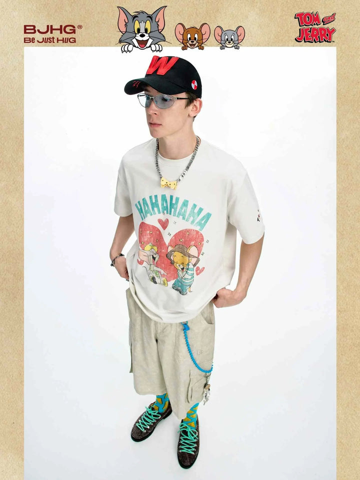 man wearing oversized white Tom and Jerry cotton t-shirt with cartoon print and beige shorts