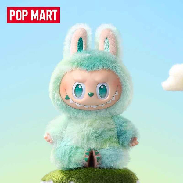 Furry Labubu doll in green bunny costume sitting on grassy mound, Pop Mart collaboration.