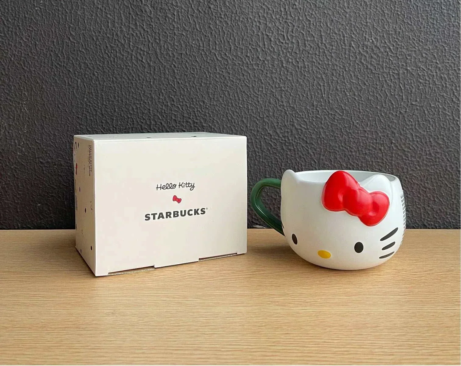 كوب Starbucks بتصميم Hello Kitty مع غطاء وقشة باللون الأخضر.