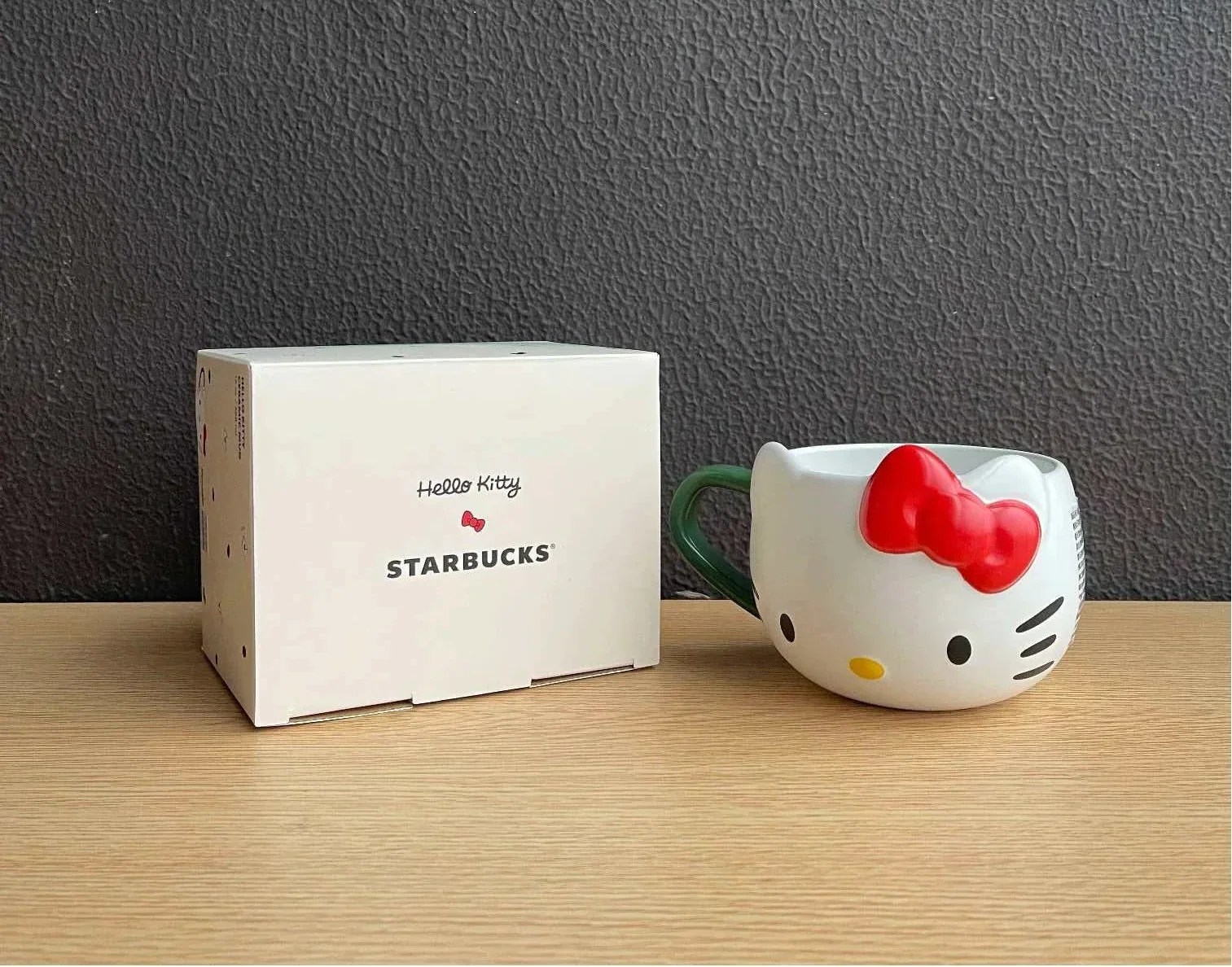 كوب Starbucks بتصميم Hello Kitty مع غطاء وقشة باللون الأخضر.