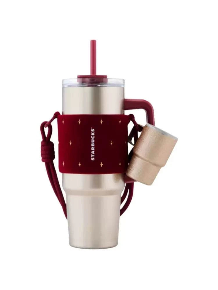 كوب Tumbler من Starbucks ذهبي مع حامل أحمر فاخر.