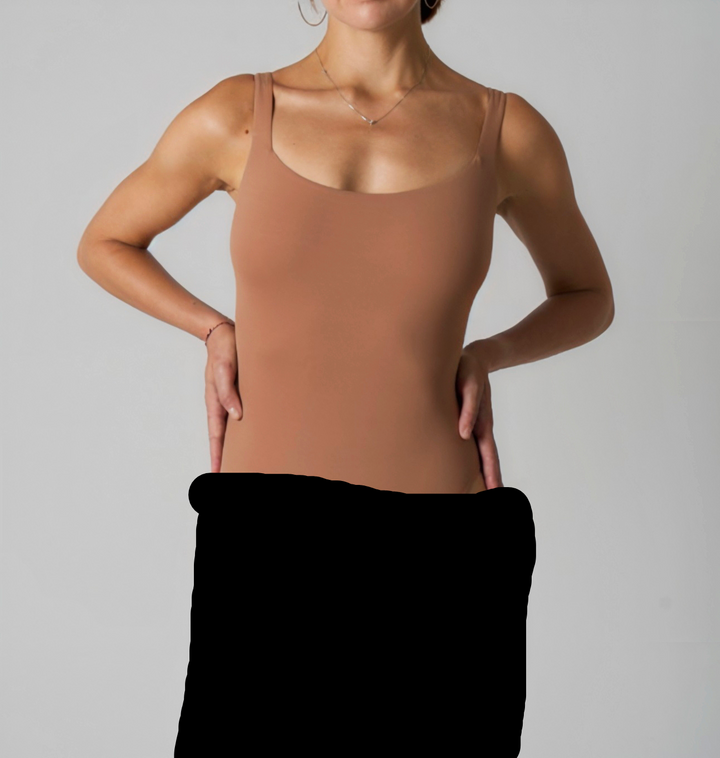Seamless SKIMS Kardashian brown scoop neck thong bodysuit highlighting body shape.