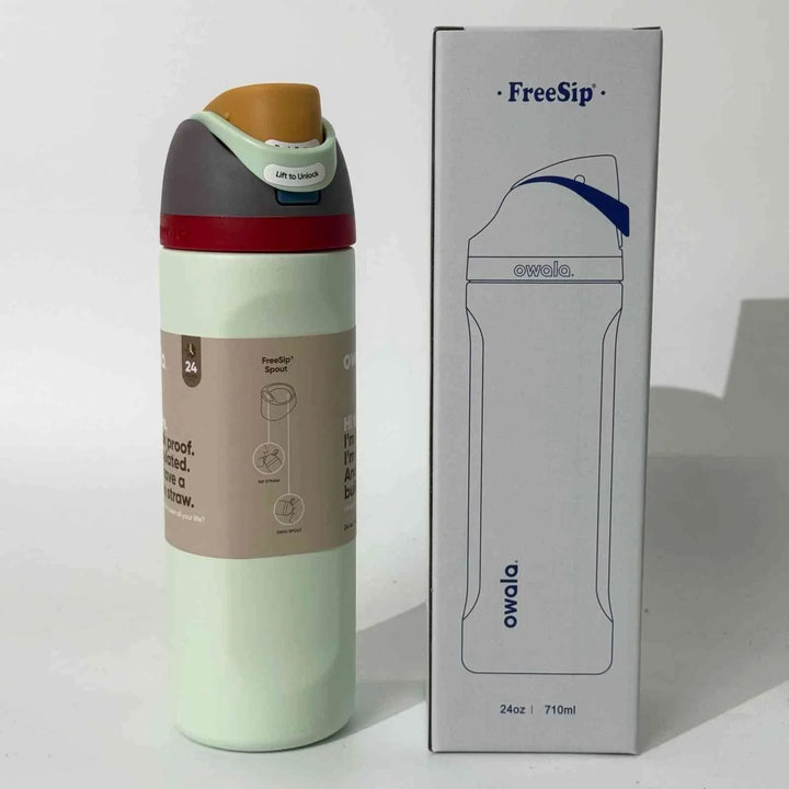 Owala FreeSip stainless steel water bottle with dual spout, leak-proof design, and 24-hour cold retention next to its packaging box