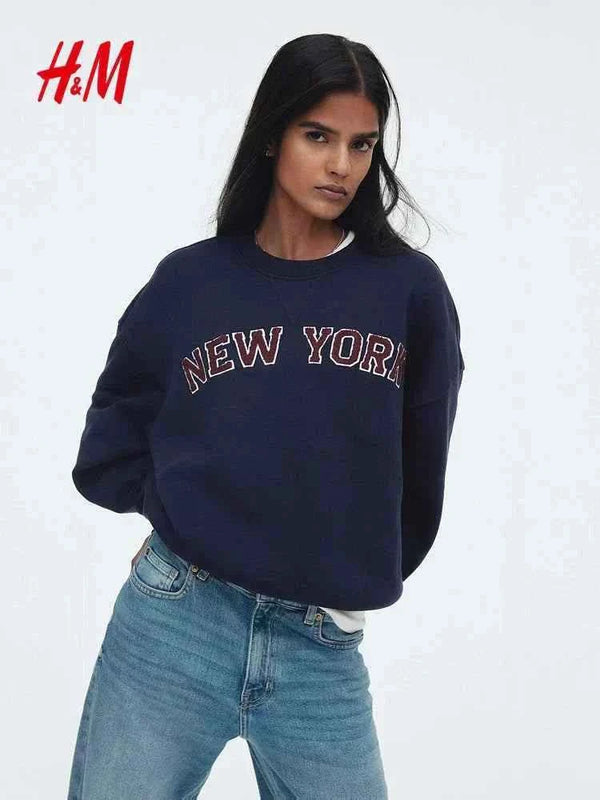 سويت شيرت نسائي كاجوال أصلي من H&M باللون الأزرق الداكن بطبعة نيويورك وتصميم مريح وعصري