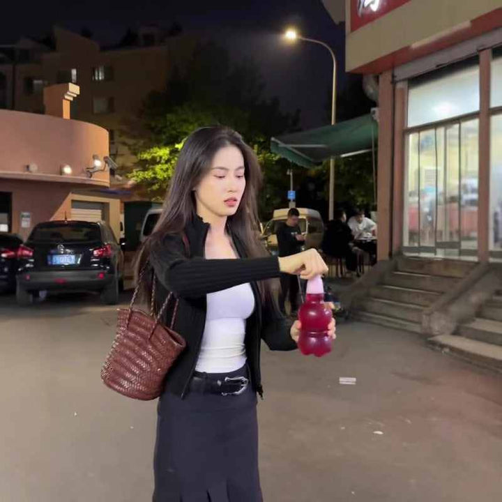 Woman wearing white SKIMS توب برقبة مربعة Essential Square Neck Tank outdoors at night