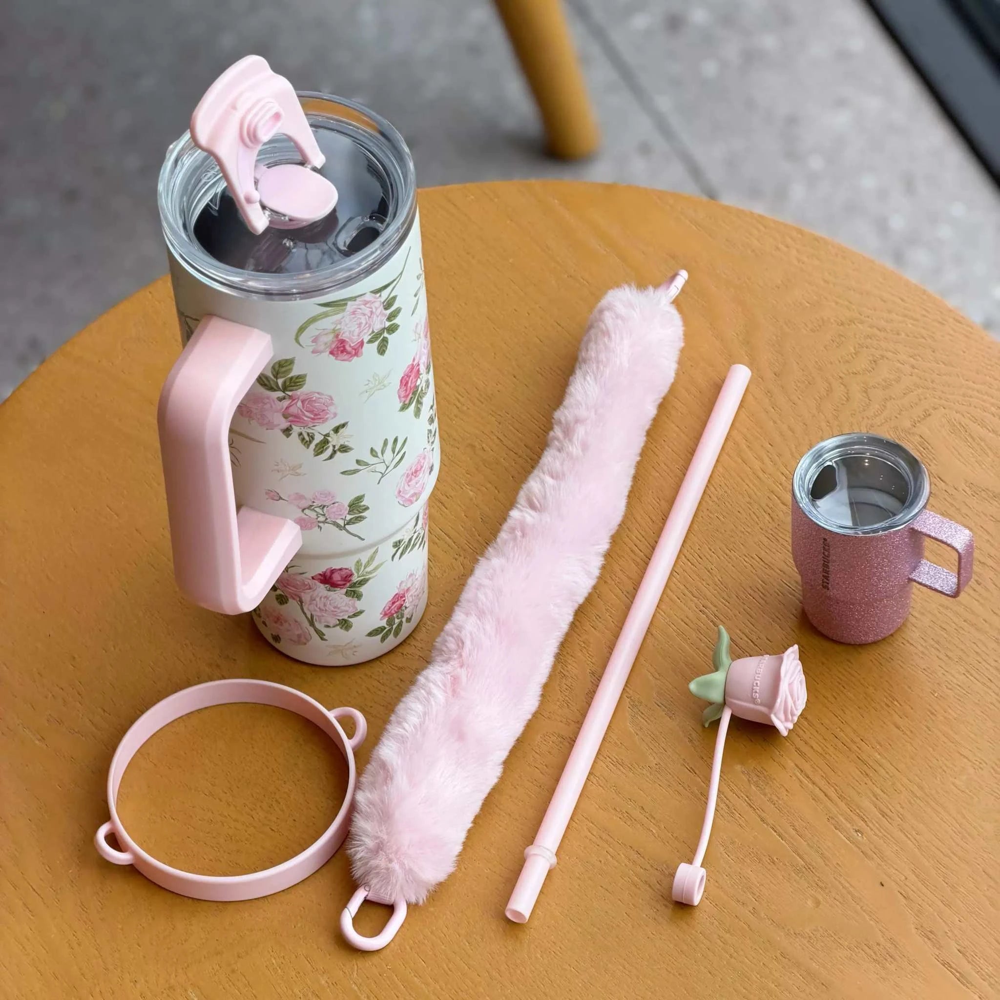كوب Starbucks حراري وردي بنقشة زهور مع غطاء فرو ومجموعة ملحقات.