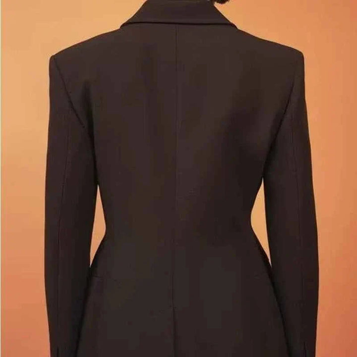 Back view of a women's European and American style fitted black blazer on a mannequin against a beige background