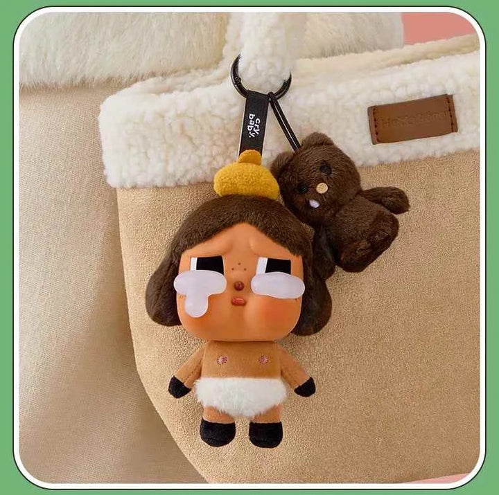 POP MART Crybaby doll keychain hanging on a bag, with plush details and a unique costume.