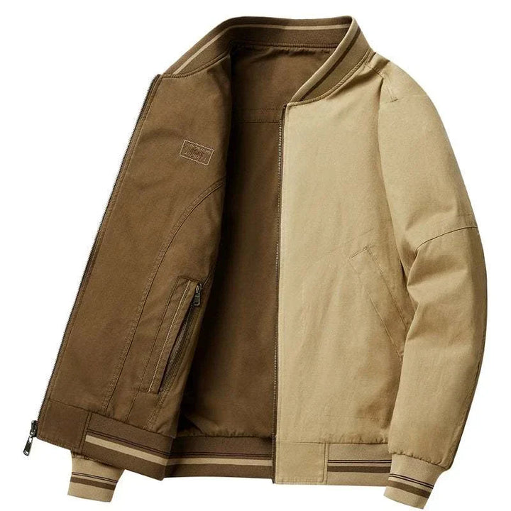 جاكيت لونين رجالي كاجوال قابل للعكس بخامة كانفاس بقصّة مريحة وألوان بُنية وبني فاتح مع ياقة وأساور مخططة وسحّاب مزدوج