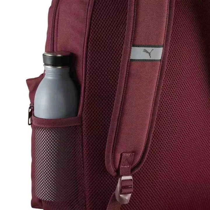 PUMA Athletics burgundy backpack with padded adjustable straps, side mesh pocket, and durable fabric.