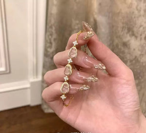 سوار نسائي ذهبي مرصع بأحجار الكريستال الأنيقة.