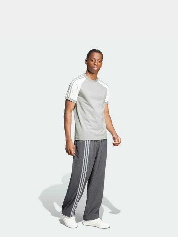 رجل يرتدي Adidas تيشيرت رياضي عصري بأكمام راجلان رمادي فاتح وجوانب بيضاء شبكية