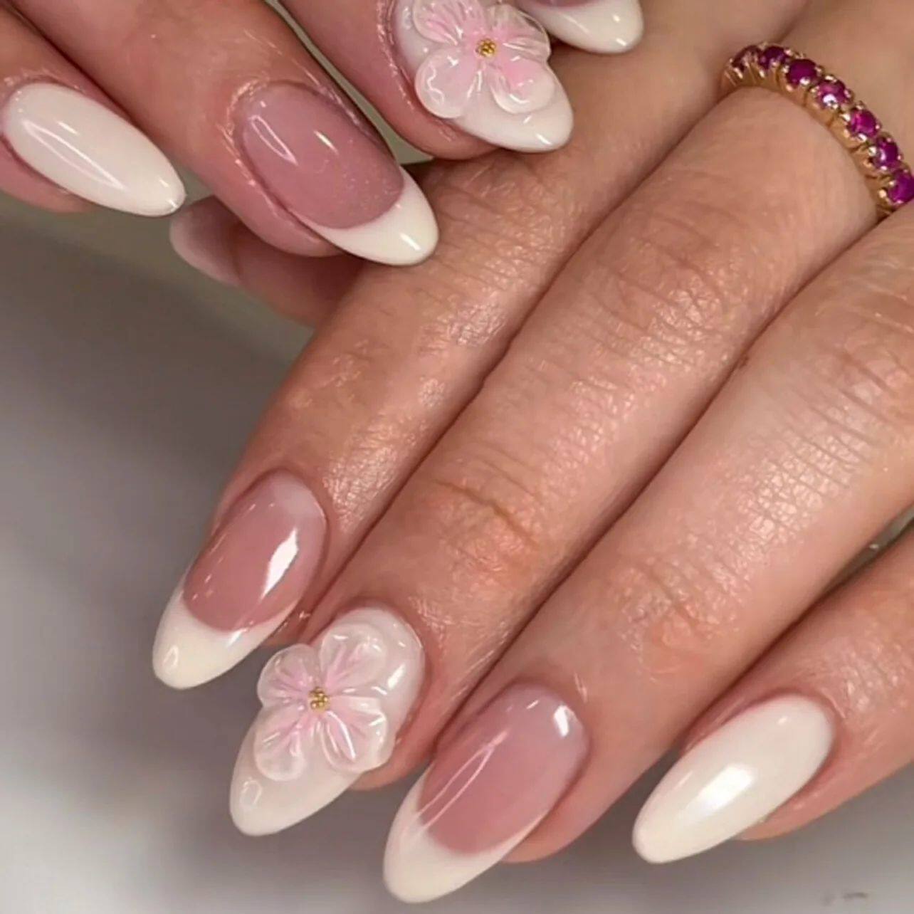 أظافر تركيب Press-on Nails بتصميم زهور بارزة وألوان وردية.