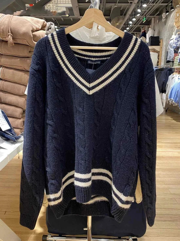 Classic cable knit winter sweater with striped edges in navy blue and off-white, perfect for warmth and style