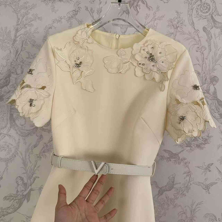 Elegant floral dress with pearl embellishments and unique lace sleeves.