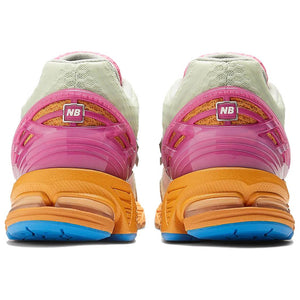 Rear heel view of a pair of Action Bronson x New Balance shoes 1906R model "Rosewater," featuring glossy hot pink molded TPU support cages with square NB logos, textured orange knit underlays, pale green mesh collars, vibrant orange N-ergy cushioned midsoles, and bright blue rubber outsoles.