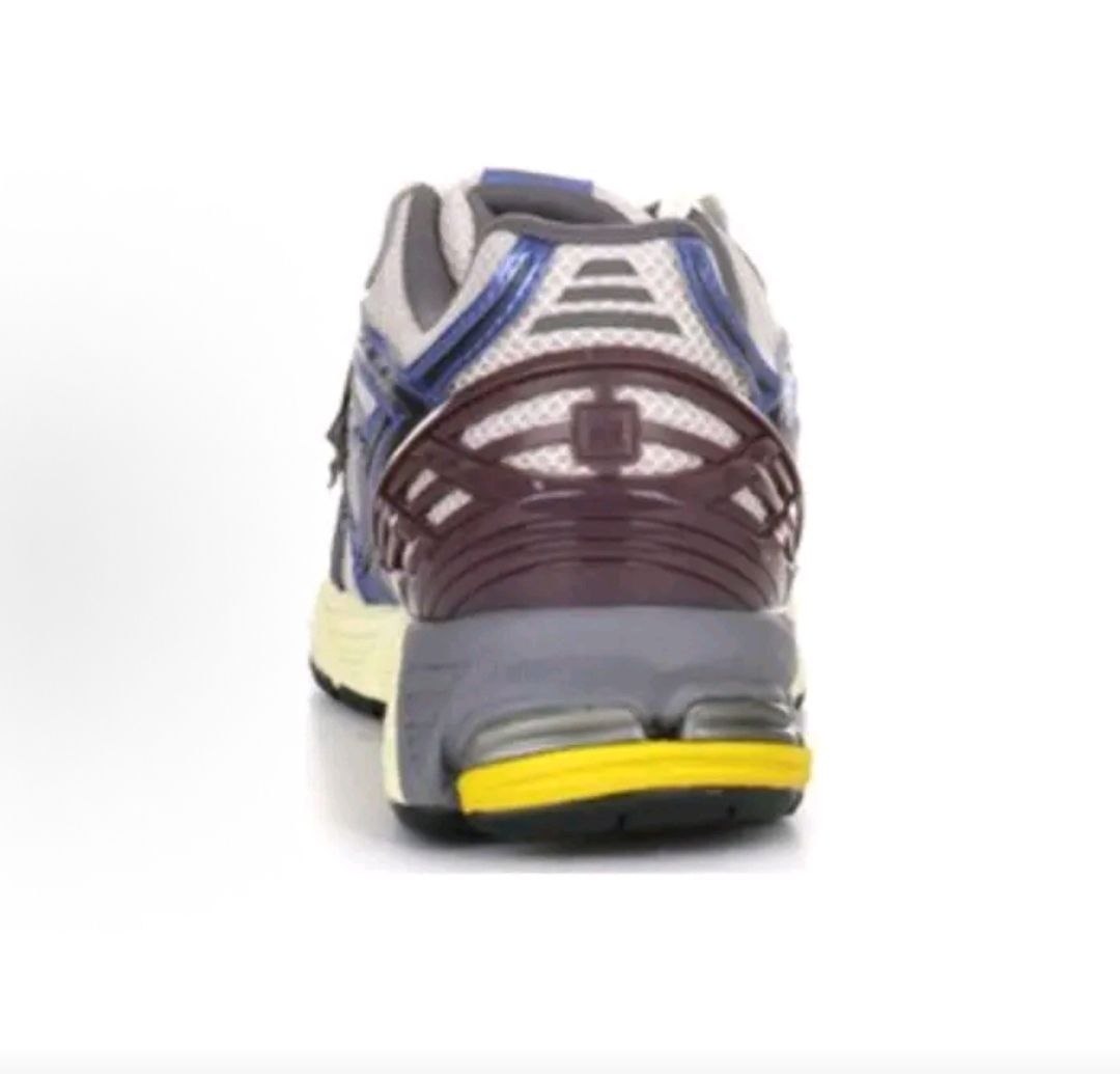 Rear view of white, metallic blue, and purple New Balance shoes 1906R.