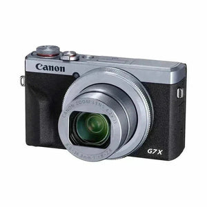 Angled front view of the silver Canon PowerShot G7 X Mark III showing the lens ring and compact body.