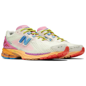 Three-quarter profile shot of a pair of Action Bronson x New Balance shoes 1906R model "Rosewater," featuring pale green mesh uppers with translucent pink undertones, bright blue N-Lock logos, neon yellow laces, pink textured mesh tongues, hot pink heel TPU cages, and multi-toned orange and yellow N-ergy cushioned midsoles.
