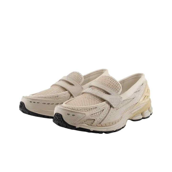 Beige New Balance 1906 sneakers with mesh fabric, leather accents, and rubber soles, designed for comfort and style.