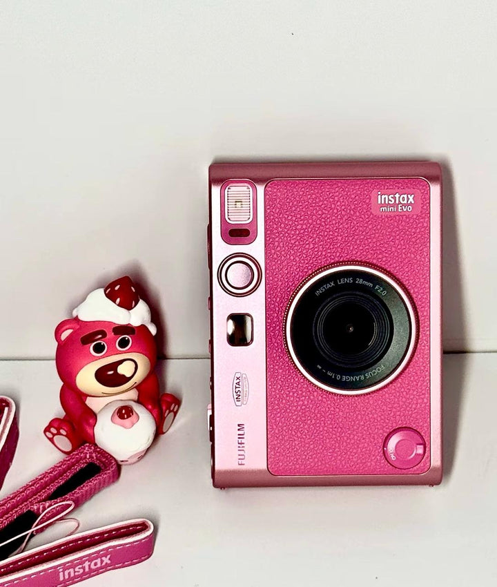 كاميرا فورية هايبرد FUJIFILM Instax Mini Evo باللون الوردي، تصميم أنيق مع عدسة 28mm F2.0 وفلاتر متعددة، خلفية شاشة LCD وشحن USB-C.