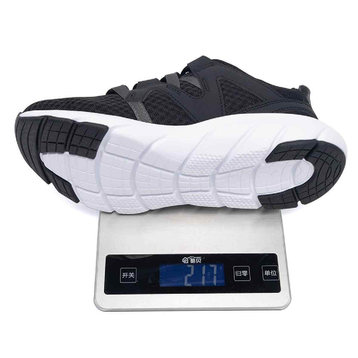 Puma black athletic shoe with gray stripes and white sole on digital scale.