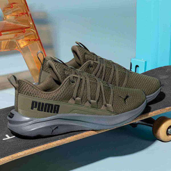 Puma men's olive and gray athletic sneakers on skateboard, featuring mesh upper and innovative lacing system.