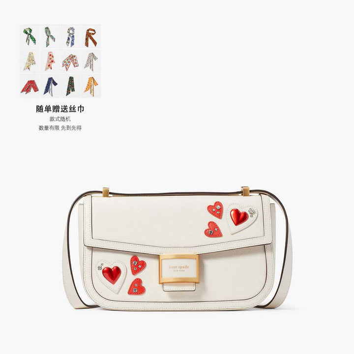 Kate Spade white bag with red hearts and crystal accents, adjustable strap, gold logo clasp.