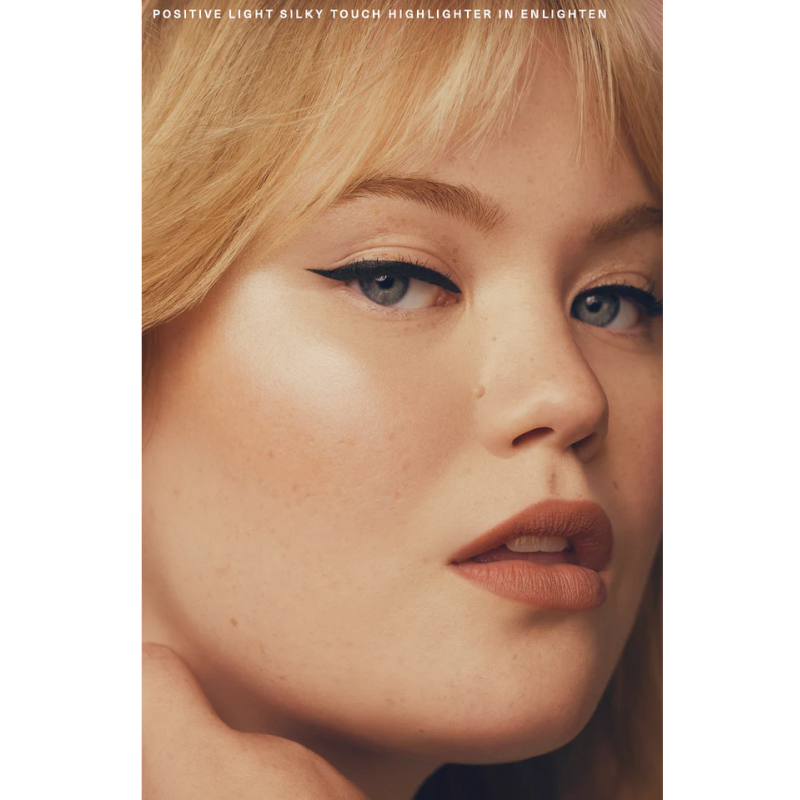 وجه عارضة عن قرب يظهر عليه أثر الهايلايتر بشعار Rare Beauty