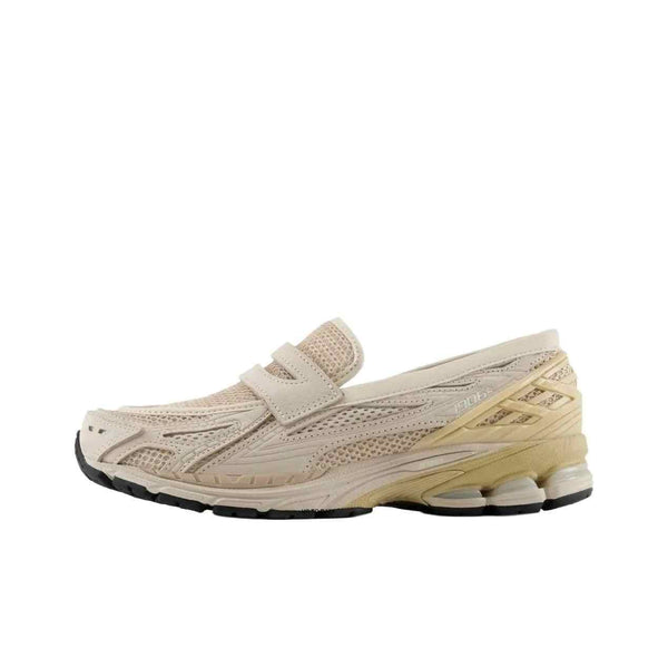 Beige New Balance 1906 sneaker mule with mesh fabric, leather overlays, and rubber sole.
