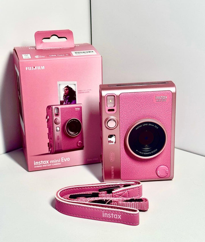 كاميرا فورية هايبرد FUJIFILM Instax Mini Evo باللون الوردي الخاص مع حزام وردي.