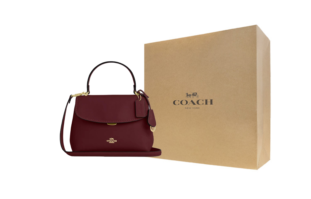 حقيبة يد Coach بتصميم كلاسيكي ولون أحمر داكن أنيق.