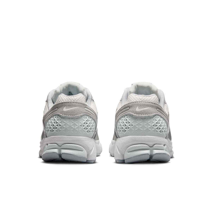 Rear view of Nike VOMERO 5 women's sneakers in light gray and white, showcasing breathable and shock-absorbing design.
