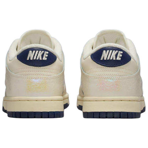 حذاء Nike Dunk Low بتفاصيل عاكسة للضوء لون كريمي.
