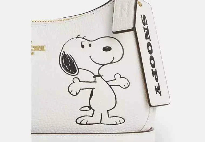 حقيبة كتف تيري من Coach X Peanuts، جلد حصى أبيض، تصميم سنوبي، حزام قابل للفصل.
