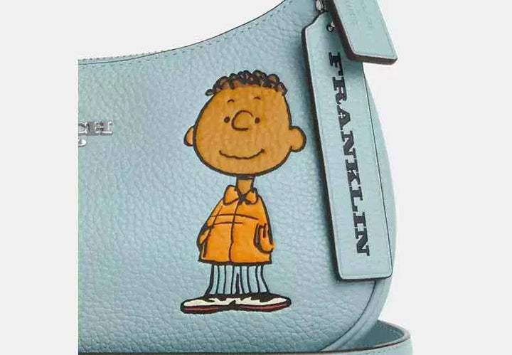 Terry shoulder bag from Coach X Peanuts with Franklin character in polished pebble leather.