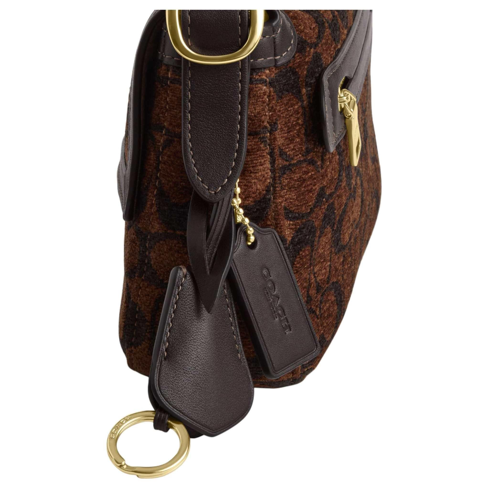 حقيبة كتف COACH بنقشة Signature المميزة باللون البني.